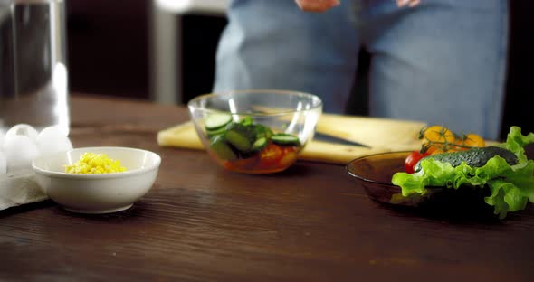 Women's Hands Tear a Fresh Salad Into a Bowl