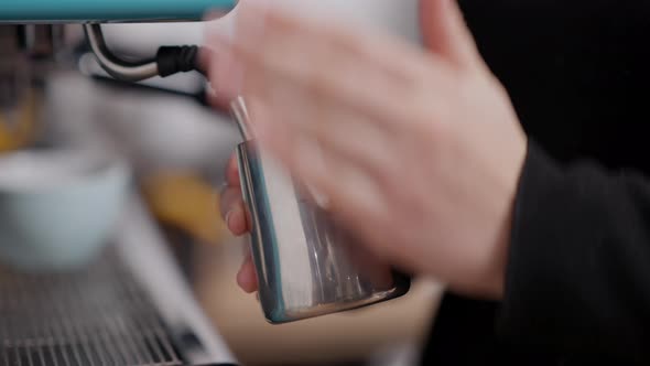 Closeup of Female Hands Warming Milk Using Coffee Machine in Cafe or Restaurant