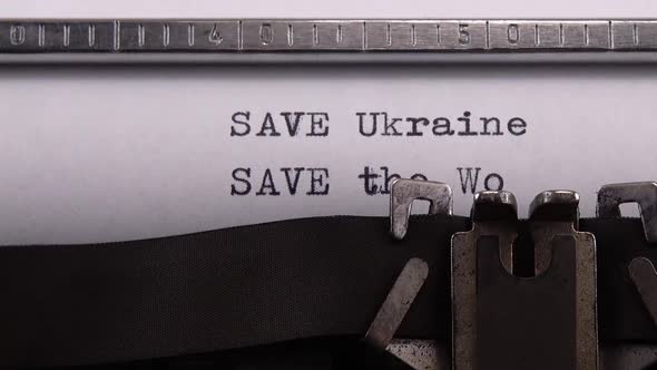 Typing phrase "SAVE Ukraine SAVE the World" on retro typewriter.