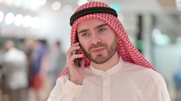 Portrait of Cheerful Arab Businessman Talking on Smartphone