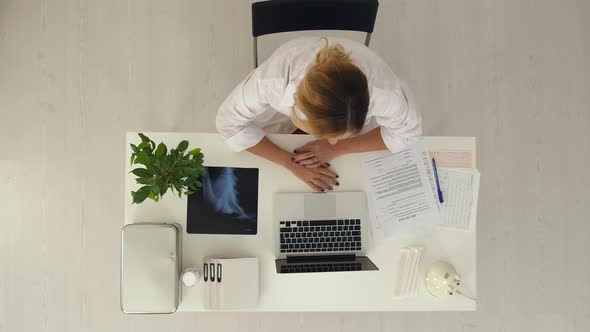 Female Doctor Sitting and Making Consultation with Jar of Pills in Hands