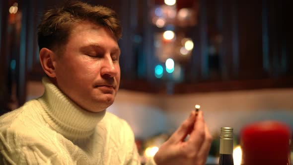 Closeup Portrait of Smiling Loving Man Admiring Engagement Ring Sitting at Home in Kitchen