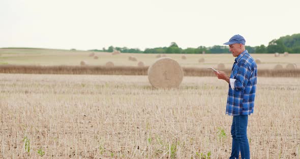 Farmer Using Digital Tablet While Examining Field