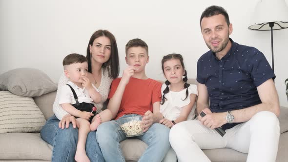 American Family Watching TV Sitting at Home on the Couch Dad Holding a Remote Control