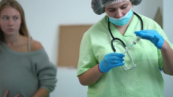 Portrait of Confident Nurse Filling Syringe with Covid19 Drug Solution in Vaccination Center