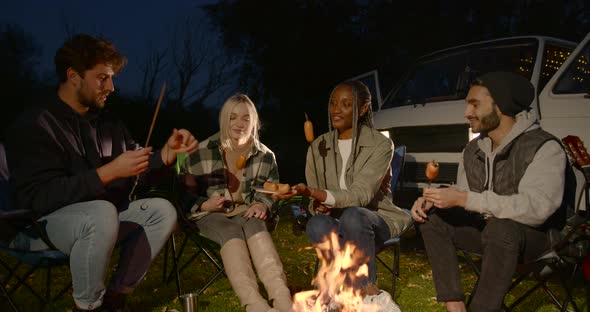 Four Young Tourists are Sitting on Chairs By the Fire