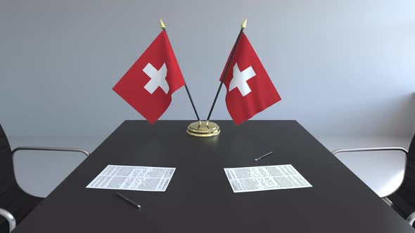 Flags of Switzerland and Papers on the Table