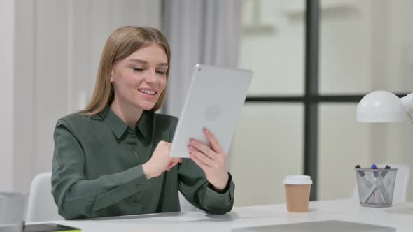 Video Chat on Tablet By Young Woman at Work
