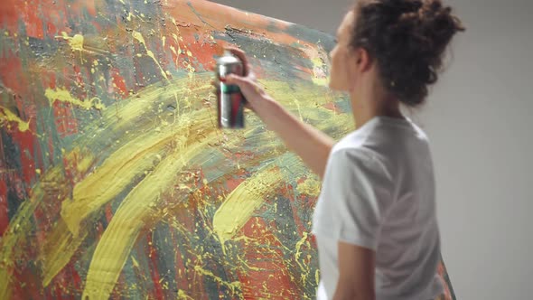 Modern Art Female Artist Draws with Spray Paint on a Large Canvas in a White Room a Talented Artist