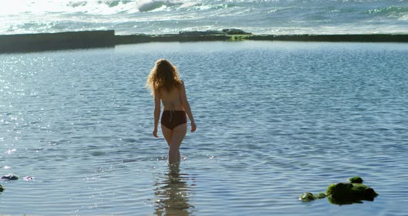 Woman standing in the sea at beach 4k