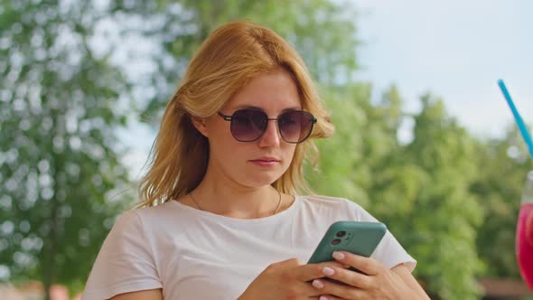 Young Woman Enjoys Talking on the Phone Texting with Someone in a Wonderful Place Sitting in a White