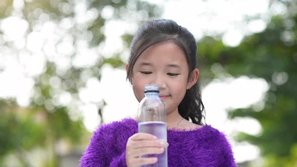 Beautiful Asian Girl Drinks Water From A Bottle Outdoor