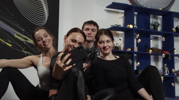 Three Girls and Guy Fool Around on Camera Sitting on the Floor