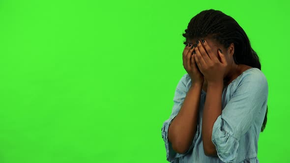 A Young Black Woman Cries with Hands Over Her Face - Green Screen Studio