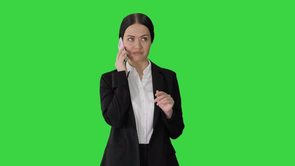 Young Businesswoman Talking on Her Phone on a Green Screen, Chroma Key.