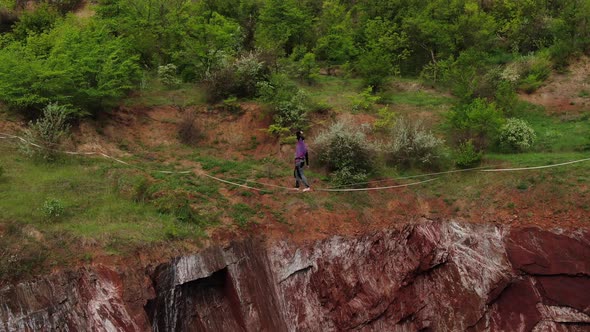 Aerial View on a Man Slacklining Over a Massive Pit Scary Height