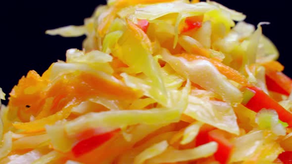 salad of fresh vegetables on a white plate rotates on black background.