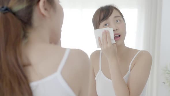 Beautiful young asian woman smile and joy with skin care use oil blotting paper on face.