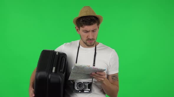 Portrait of Tourist with Suitcase Carefully Examines Map, Then Looking at Camera and Say Wow