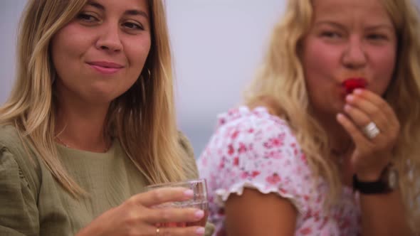 Four Women Drinking Wine By the Sea