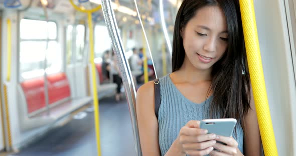 Woman looking at cellphone on train