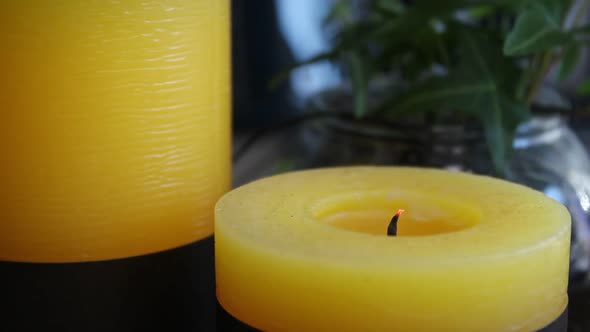 Small, scented candle blown out on an interior coffee table. Static close up shot