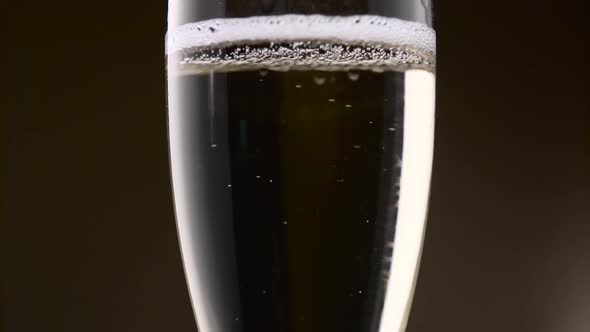 Bubbles of Champagne Are Intensely Circling in a Glass. Close Up