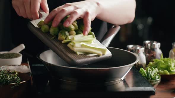 Chef Frying Green Brussels Sprouts Cabbage in Pan Closeup