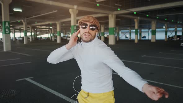 Handsome Happy Bearded Man Is Listening To Music in Smartphone Headphones and Dancing. Funny Dancer