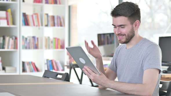 Young Man Doing Video Chat on Tablet in Office 