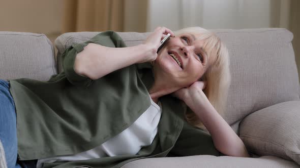 Old Happy Caucasian Grandmother 60s Senior Woman Talking Chatting Phone with Friends Family Lying on
