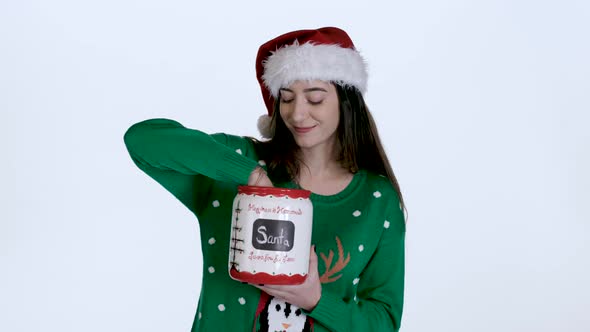 Young woman Takes Cookie out of Christmas Cookie Jar (White Screen)