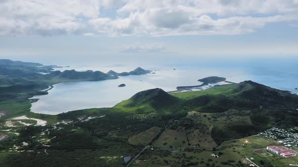 Aerial footage of a green hilly island in the blue sea in Antigua and Barbuda