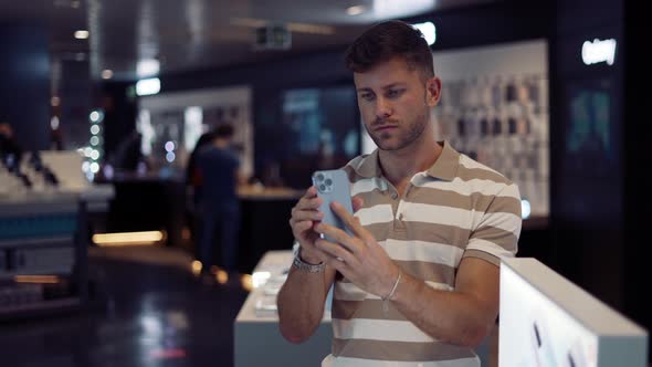 Man Choosing Smartphone in Modern Shop