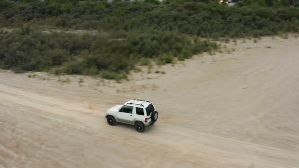Aerial View of a Car Driving on Sand
