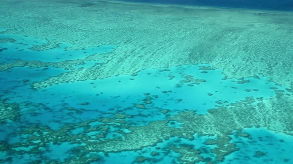 The Great Barrier Reef As Seen From the Airplane. Beautiful Ocean Colors, Aerial View. Slow Motion