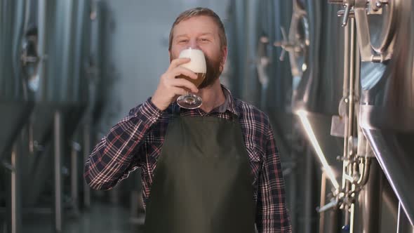 Portrait. Cheerful Male Brewer Tastes Freshly Brewed Beer To Taste Leaving Foam on His Mustache