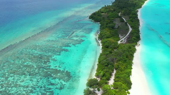 Natural drone tourism shot of a white sand paradise beach and blue water background in 4K