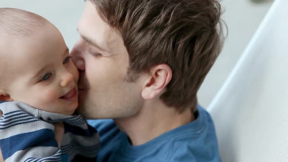 Father kissing baby son on cheek