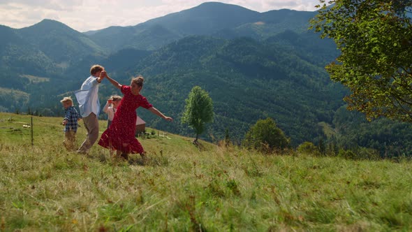 Family Playing Active Games on Green Grass Mountain