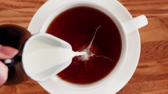 Pouring Milk Into Black Tea Top View