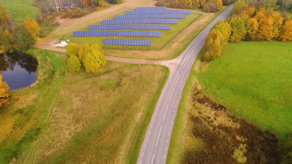 Aerial view of solar panel rows near a forest during Autumn, Estonia.