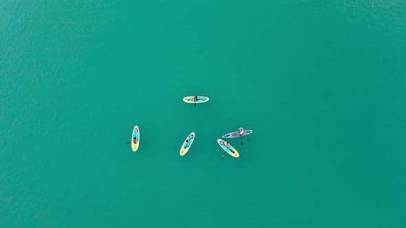 People Ride on SUP Board in the Mountain Lake