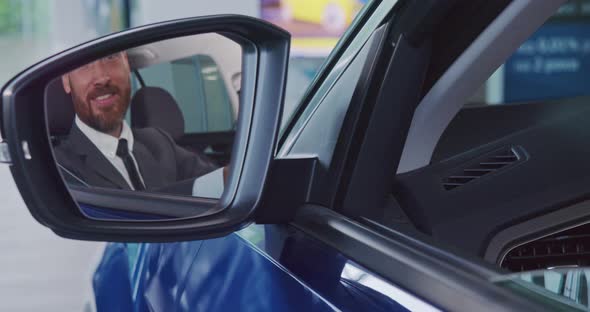 Happy Businessman Sitting in New Car and Showing Thumb Up