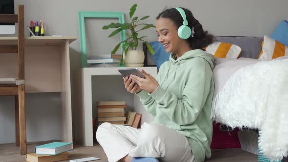 Happy Mixed Race Teen Girl Video Calling on Digital Tablet at Home