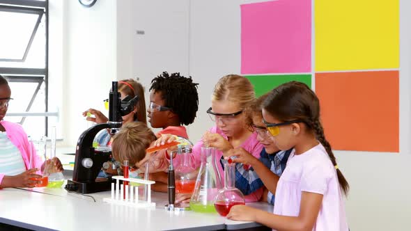 Kids doing a chemical experiment in laboratory