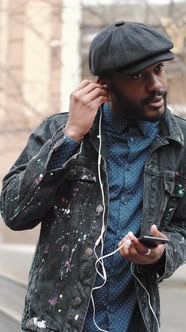 African American Man in Hat Listening to Music Outdoors