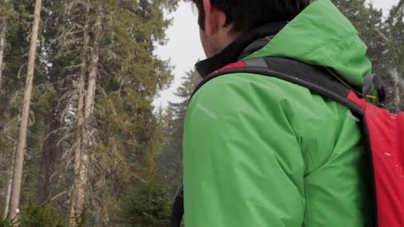 A man and woman couple hiking while it is snowing in mountains in the winter