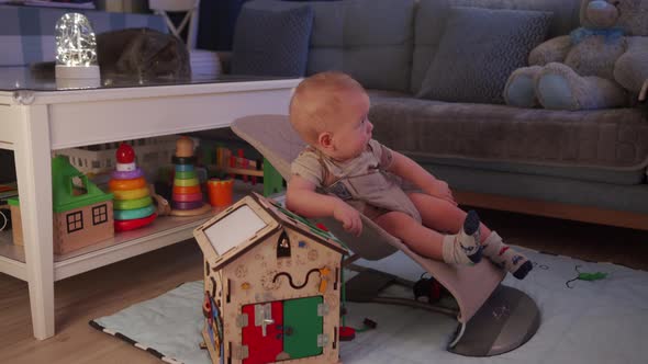 Baby Boy Playing with Wooden Busy House Montessori Educational Toy at Home