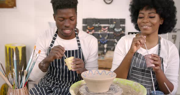 Black Couple Decorating Plate in Workshop During Class